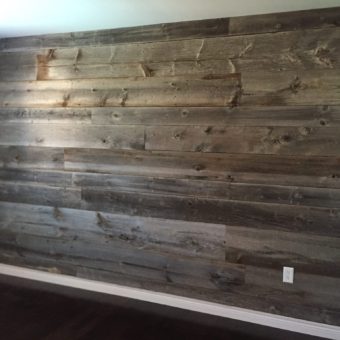 Grey barnwood bedroom feature wall with bed